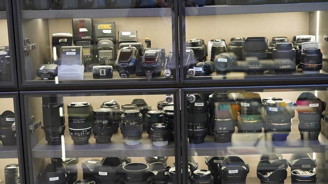 二手鏡頭與閃燈陳列櫃，含 Nikon、Sigma、Tamron 等配件